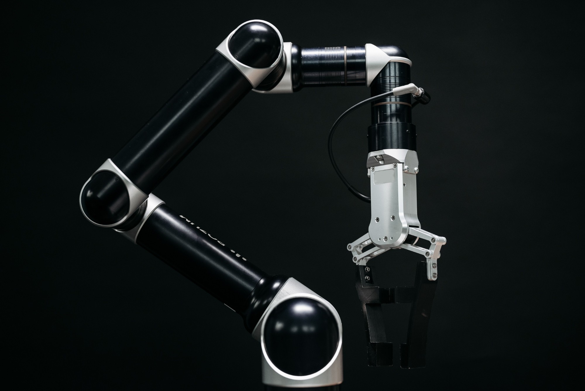 A black robot arm with a gripper